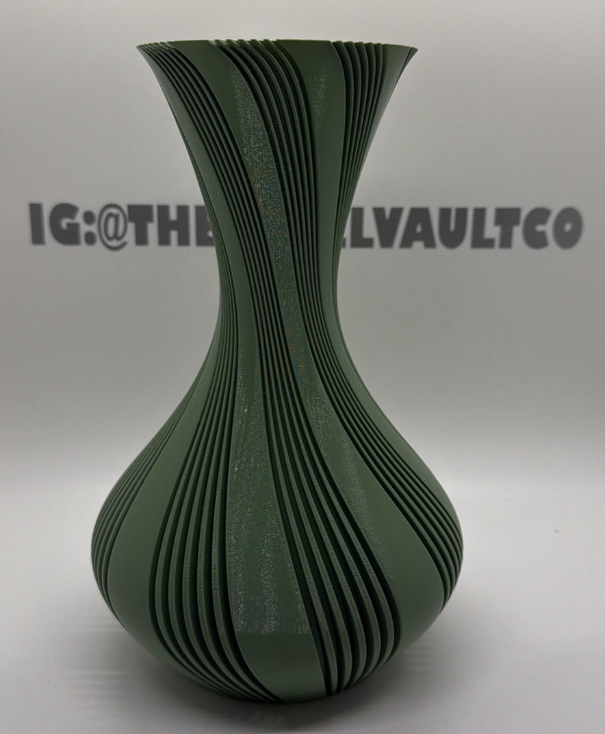 A green 3d vase with a flared neck and a bulbous base, decorated with dark green wavy vertical stripes, set against a white background with a watermark.