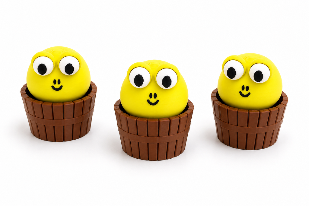Three cute 3D printed monster clicker fidget toys. Three cute green cartoon monsters with large white eyes and black pupils, nestled in brown basket-like holders, arranged side by side on a white background.